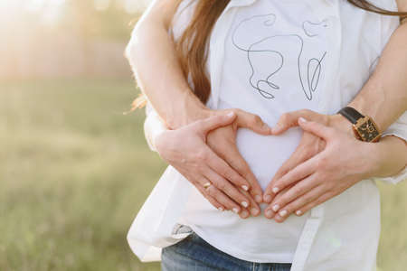 Young heterosexual pregnant couple in an outdoor parkの写真素材