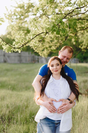 Young heterosexual pregnant couple in an outdoor parkの写真素材