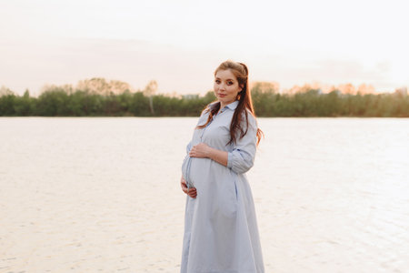 Pregnant girl in summer outdoors in the setting sunの写真素材