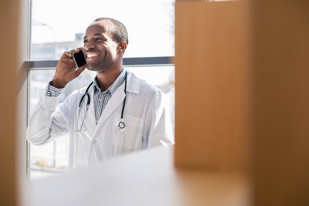 Show your smile. Positive man wearing medical uniform and keeping smile on his faceの写真素材