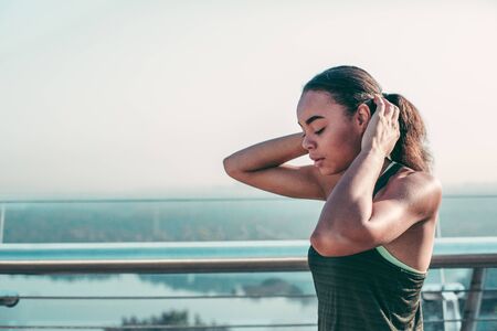 Calm young woman on the bridge touching her hair stock photo