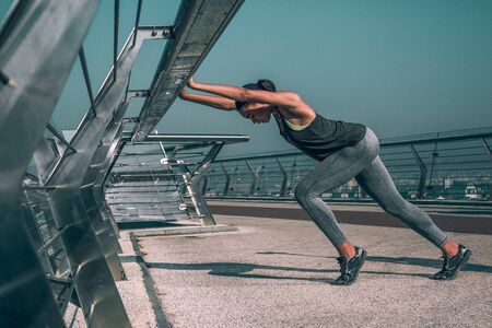 Sportswoman putting hands on the bridge banister stock photo