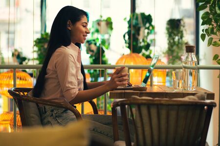 Confident young lady using laptop in the cafeの写真素材
