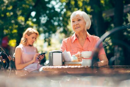 Relaxed aged woman with delicious hot coffee stock photoの写真素材