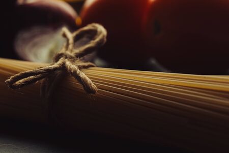 Uncooked spaghetti with rope bow on themの写真素材