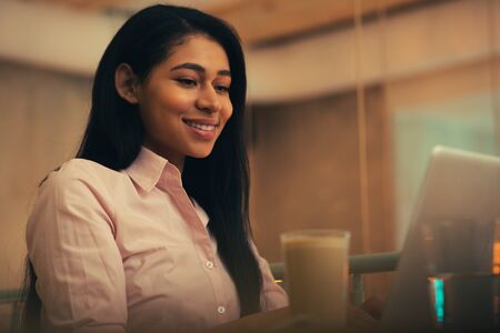 Young specialist sitting with her laptop and smiling