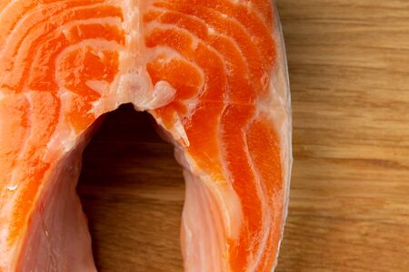 Piece of red salmon close up image on wooden surface