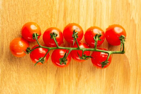 Top view of the green branch with ten cherry tomatoes on itの写真素材