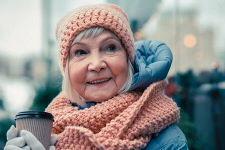 Portrait of happy aged woman with cup of coffeeの写真素材