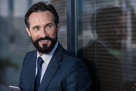 Portrait of a positive smiling businessman looking aside