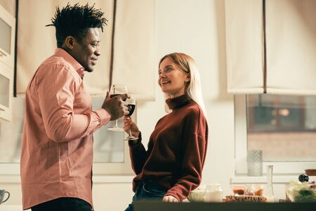 Waist up of woman standing near the table and drinking wine with manの写真素材
