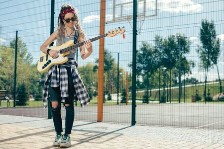 Full length of concentrated musician playing the guitar outdoorsの写真素材