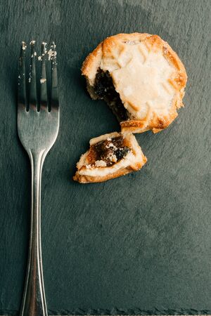 Vertical photo of metal fork and mince pie nearの写真素材