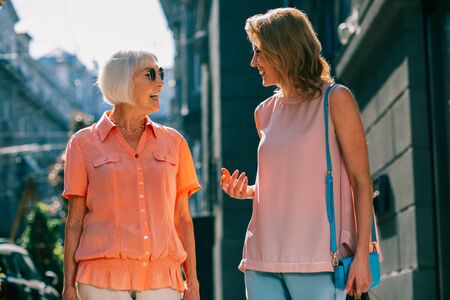 Two smiling women communicating outdoorsの写真素材