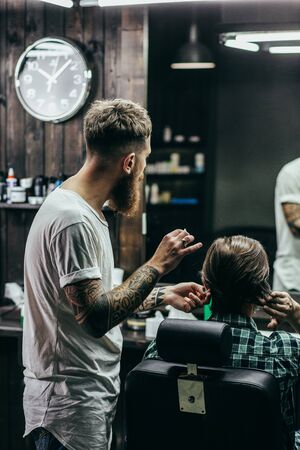 Waist up of professional barber standing next to the clientの写真素材