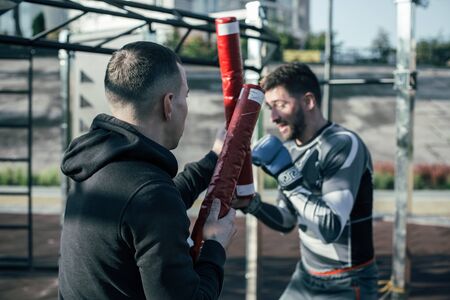 Close up of young man holding boxing stick and the boxer getting readyの写真素材
