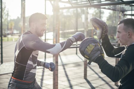 Emotional boxer making his punch while using focus mittensの写真素材