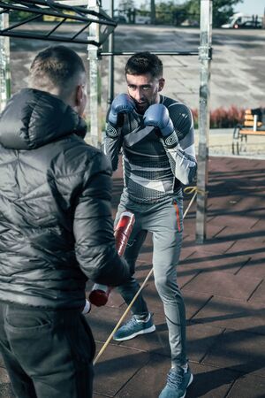 Confident boxer looking at the trainer while jumping over the ropeの写真素材
