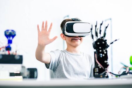 Waist up of a joyful little boy testing his robotic creationの写真素材