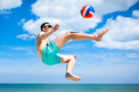 the guy on the beach playing with a ballの写真素材