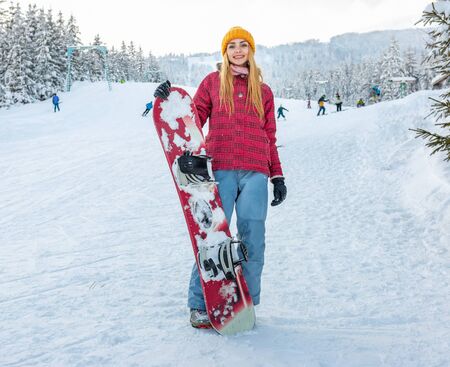 beautiful girl smile alone with snowboard, winter sport activity, forest snow outdoors lifestyleの写真素材