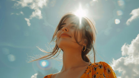 Portrait of a young beautiful woman on a background of blue skyの素材