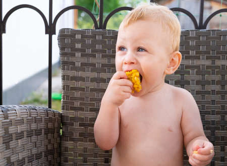 boy eating sweet corn outdoor summer timeの写真素材