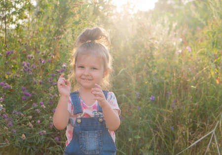 little girl with a funny ponytail on top of her head in nature.の写真素材