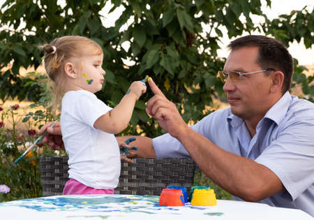 father and daughter are playing by color painting together with fully happiness moment, concept of learning activity for kid in family lifestyleの写真素材