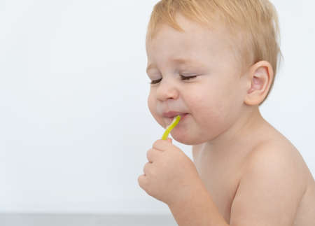 Baby boy trying and tasting new food. Dieting, vegetarian and healthy nutrition concept.の写真素材