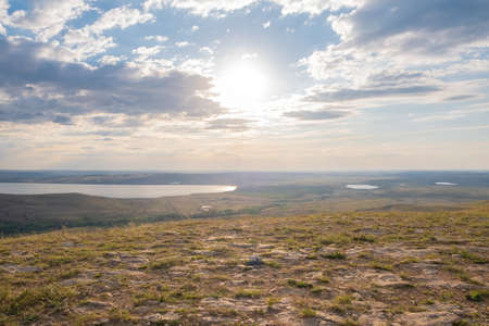 view of a lake and hills landscape at sunset.の写真素材