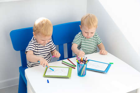 Education and hobby. two blonde twins boys paint with felt pen.の写真素材