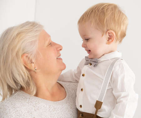 Happy good looking senior women with hir adorable grandson indoor.