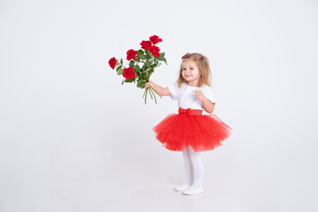 toddler girl in red skirt and holding bouquet of roses on white background. Valentine Day concept.の写真素材