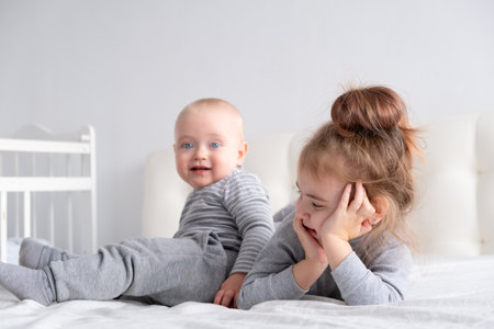 baby boy and little girl sister having fun at home on bed. Home activities for kidsの写真素材