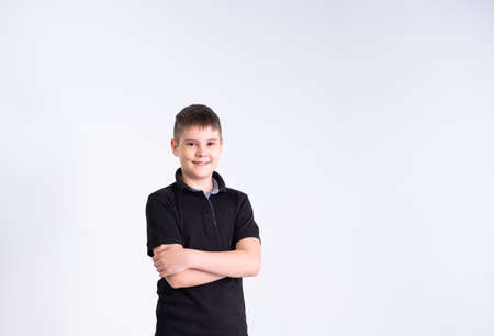 Portrait of boy teenager in black t-shirt looking at camera, smiling with positive feeling on his...