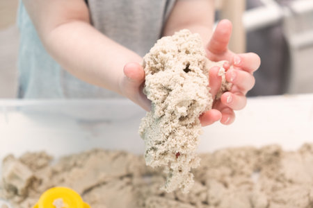 boy hands playing with kinetic sand at home. Early age education. Toddler playing.の写真素材