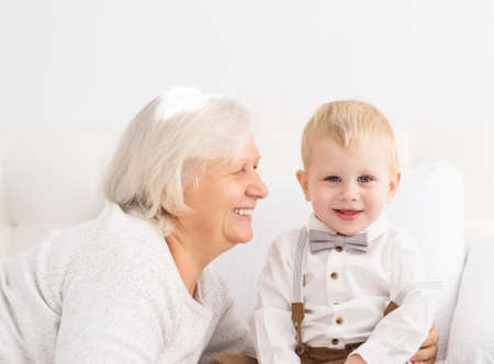 Happy good looking senior women with hir adorable grandson indoorの写真素材
