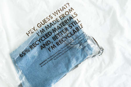 blue jeans in plastic bag with tag recycled materials and recyclable. zero waste conceptの写真素材
