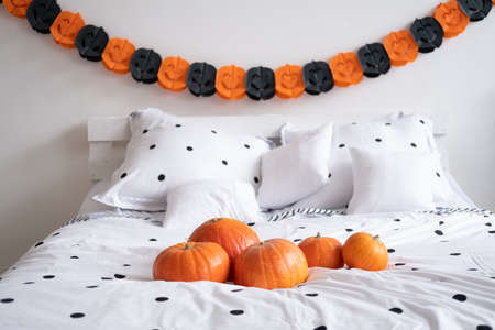 Home decor in bedroom for Halloween celebration with garland and pumpkins.の写真素材