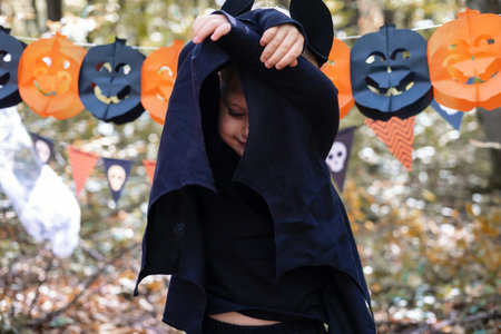 happy boy kid in halloween costume having fun in halloween decorations outdoor