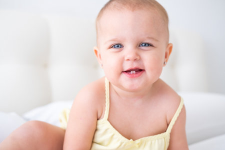 portrait of cute baby girl smiling with first milk teeth. Healthy newborn child.の写真素材