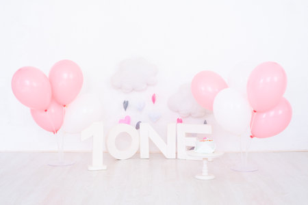 background decoration for first birthday celebration with cake, letters saying one and pink balloonsの写真素材