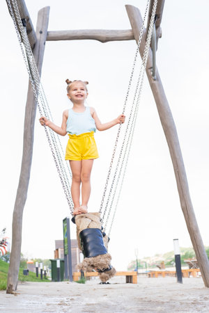 cute little child girl in colorful clothes playing on kids playground in summer day.の写真素材