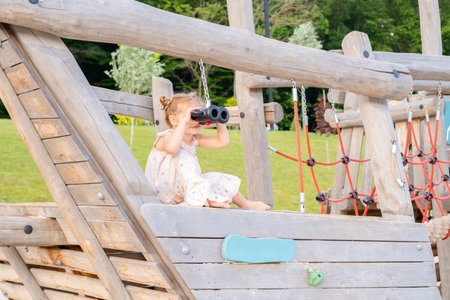 cute little child girl in dress playing on kids playground in summer day.の写真素材