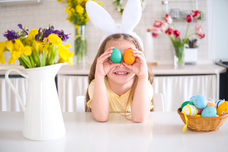cute little girl in rabbit ears on head playing egg hunting for Easter. celebrate Easter at home.
