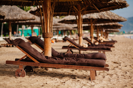 luxury beach resort with wooden sunbeds and umbrellas with nobody  in Asia, Vietnam beach, Nha Trangの写真素材