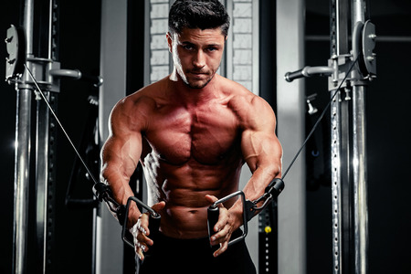 handsome bodybuilder works out  pushing up excercise in gymの写真素材