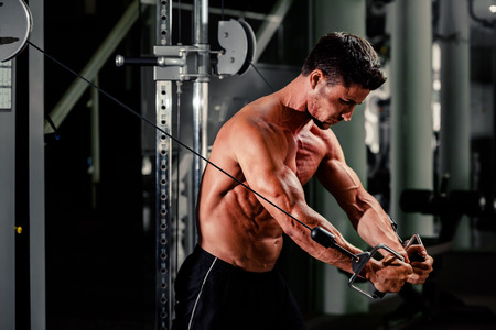 handsome bodybuilder works out  pushing up excercise in gymの写真素材