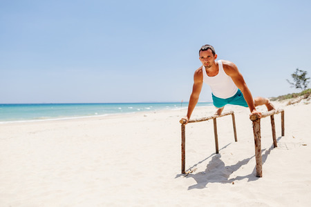 fitness handsome man work out on the beach with sea viewの写真素材